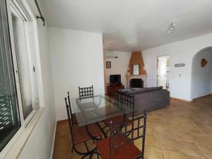 a living room with a glass table and a couch at Albufeira INN - Mulatinho V2 in Olhos de Água