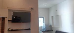 a living room with a flat screen tv on a wall at NKS Service Apartment in Pondicherry