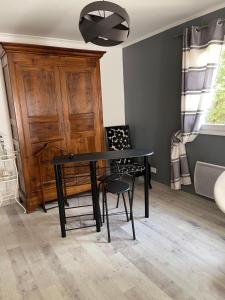 a dining room with a black table and two chairs at Grande Chambre meublee in Cornebarrieu
