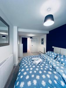 1 dormitorio azul con 1 cama con manta azul y blanca en The Corner house, en Hartlepool