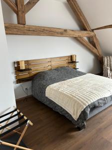 a bedroom with a bed and a chair at Au clos des sens in Demigny