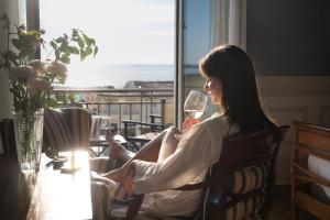 a woman sitting in a chair with a glass of wine at Palace Hotel in Viareggio