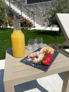 a table with a plate of food and a bottle of orange juice at Donatella Apartment 2 in Podstrana