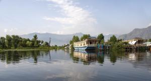 a boat is docked on a river with houses at Houseboat Shamshad in Srinagar