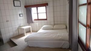 a small bedroom with a bed and a window at 隔壁棟 in Hsinchu City