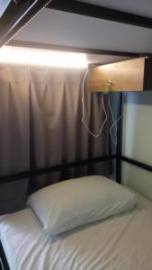 a bed with a wooden headboard and a light above it at 隔壁棟 in Hsinchu City +2 photos