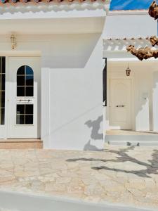 a white house with a door and a stone patio at Casa Ramón in Vélez-Rubio