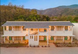 加尔加Paatlidun Safari Lodge, Jim Corbett的一座大白色房子,后面有山