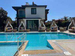 a swimming pool with a house in the background at premium park apart otel in Kemer