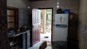 a kitchen with a white refrigerator and a sink at Hospede-se com conforto e vista privilegiada in Guaraqueçaba