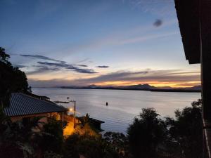a view of a large body of water at sunset at Hospede-se com conforto e vista privilegiada in Guaraqueçaba
