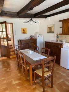 a kitchen with a table and chairs and a refrigerator at La Maison de Jeanne in Tour-de-Faure