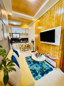 a living room with a couch and a tv on a wall at FYLL Homes Francheska Suite Calvario St Cavinti Town Proper in Cavinti