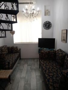 un salon avec des canapés, une télévision et un lustre dans l'établissement Cosy House, à Sofia