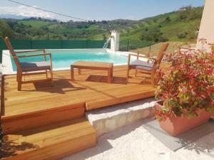 a deck with two chairs and a swimming pool at Casa Nonna Leondina in Spoltore