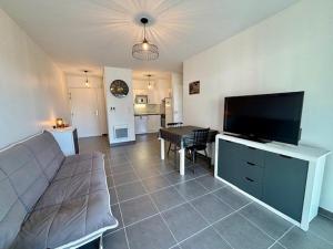 salon z kanapą i telewizorem z płaskim ekranem w obiekcie Appart 2 pers à Quiberon - 41m² - Proche plage et Thalasso - Balcon exposé sud - Parking privé - FR-1-478-236 w mieście Quiberon