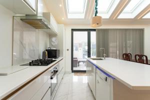a kitchen with white counters and a stove top oven at Unwind 2Bed with Garden, Sauna and Hot Tub in Barking +17 photos