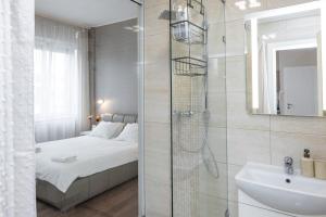 a bathroom with a shower and a bed and a sink at Top City Center Apartment! in Budapest +12 photos