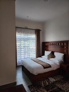 a bedroom with a large bed and a window at Mimi Home in Arusha