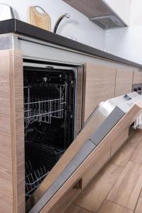 an open dishwasher in a kitchen with a sink at Top City Center Apartment! in Budapest