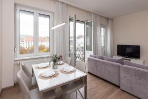 a living room with a white table and a couch at Top City Center Apartment! in Budapest