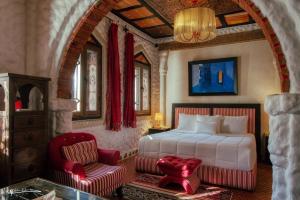 una camera da letto con un letto e una sedia rossa di Riad Hicham a Chefchaouen
