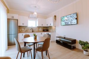 a kitchen and dining room with a table and chairs at Esperides Luxury Suites 1 in Kalamitsi