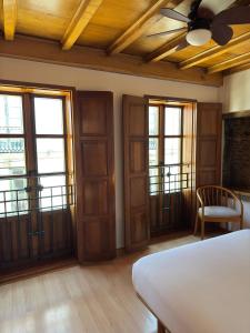 a bedroom with a bed and a ceiling fan at Apartamentos Campanas de San Juan in Santiago de Compostela