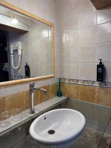 a bathroom with a sink and a mirror at Apartamentos Campanas de San Juan in Santiago de Compostela +6 photos