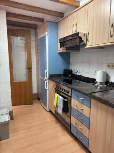 a kitchen with a stove and a refrigerator at Apartamentos Campanas de San Juan in Santiago de Compostela