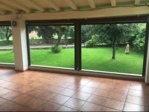 an empty living room with a view of a garden at Hotel La Palma in San Teodoro