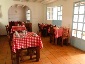a restaurant with red and white checked tables and chairs at Hotel Aqua Vitae in Villa de Leyva