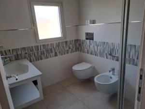 a bathroom with a toilet and a sink at Hotel La Palma in San Teodoro