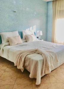 een groot wit bed met een deken erop bij Apartamento hay amal 12 in Sale