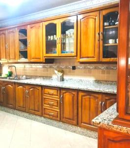 een keuken met houten kasten en een spoelbak bij Apartamento hay amal 12 in Sale