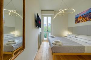 a bedroom with two beds and a mirror at BellaVita Boutique Florence in Florence