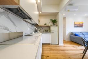 a kitchen with white countertops and a blue couch at BellaVita Boutique Florence in Florence +31 photos
