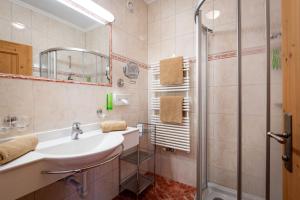 łazienka z umywalką i prysznicem w obiekcie Hotel Garni Forelle w mieście Tux