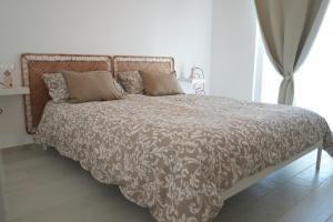 Park Room - Ischia Centro في ايسكيا: سرير مع لحاف ووسائد بنية وبيضاء