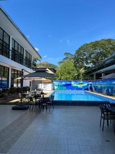 a patio with tables and chairs next to a swimming pool at Ocean Star Hotel Coron in Coron