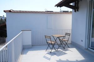 Park Room - Ischia Centro في ايسكيا: طاولة وكراسي تجلس على شرفة