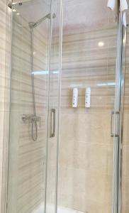 a shower stall with a glass door in a bathroom at Llanes Suites in Llanes +63 photos