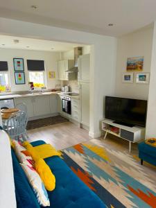 a living room with a blue couch and a kitchen at Stay-K-Belfast Cosy Entire House 10 mins from City Centre in Belfast +65 photos