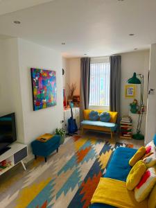 a living room with a couch and a tv at Stay-K-Belfast Cosy Entire House 10 mins from City Centre in Belfast