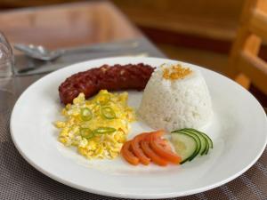 a plate of food with rice and vegetables on a table at Ocean Star Hotel Coron in Coron