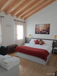 a bedroom with a large bed with a red blanket at Dalla Afra Agrialloggi in Valdobbiadene