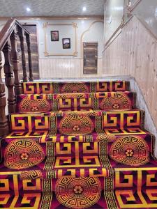 a carpet with asian writing on it on a staircase at Shobha Hotel in Manāli