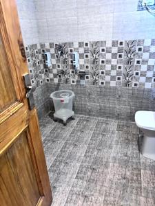 a bathroom with a toilet and a sink at Shobha Hotel in Manāli