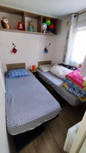two twin beds in a room with a window at Mobilhome in Saint-Arnoult