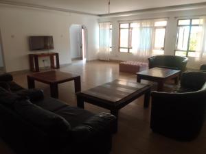 a living room with couches and tables and windows at Suswa Ranch Resort in Gicheru +8 photos